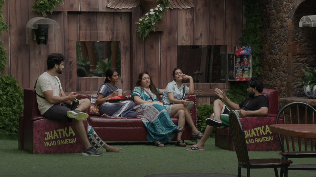 Bigg boss ott season 3 contestants sitting on sofa and talking to each other.